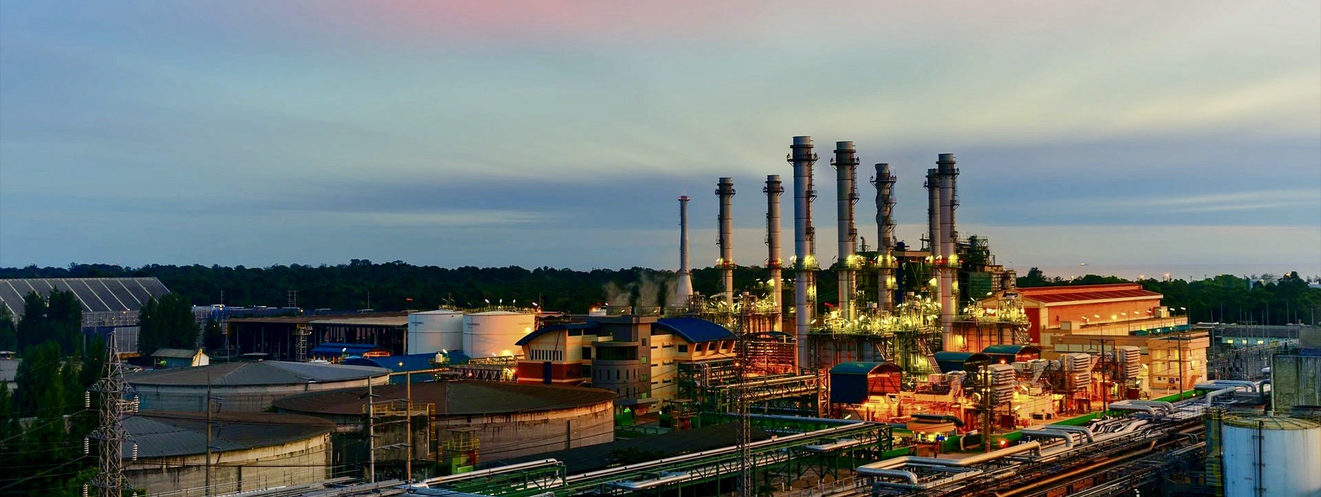 A factory with many pipes and towers in the background.